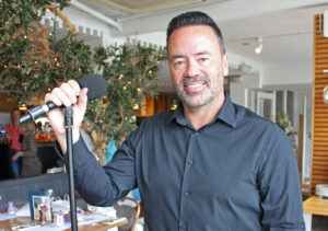 Man holding a microphone stood in a restaurant