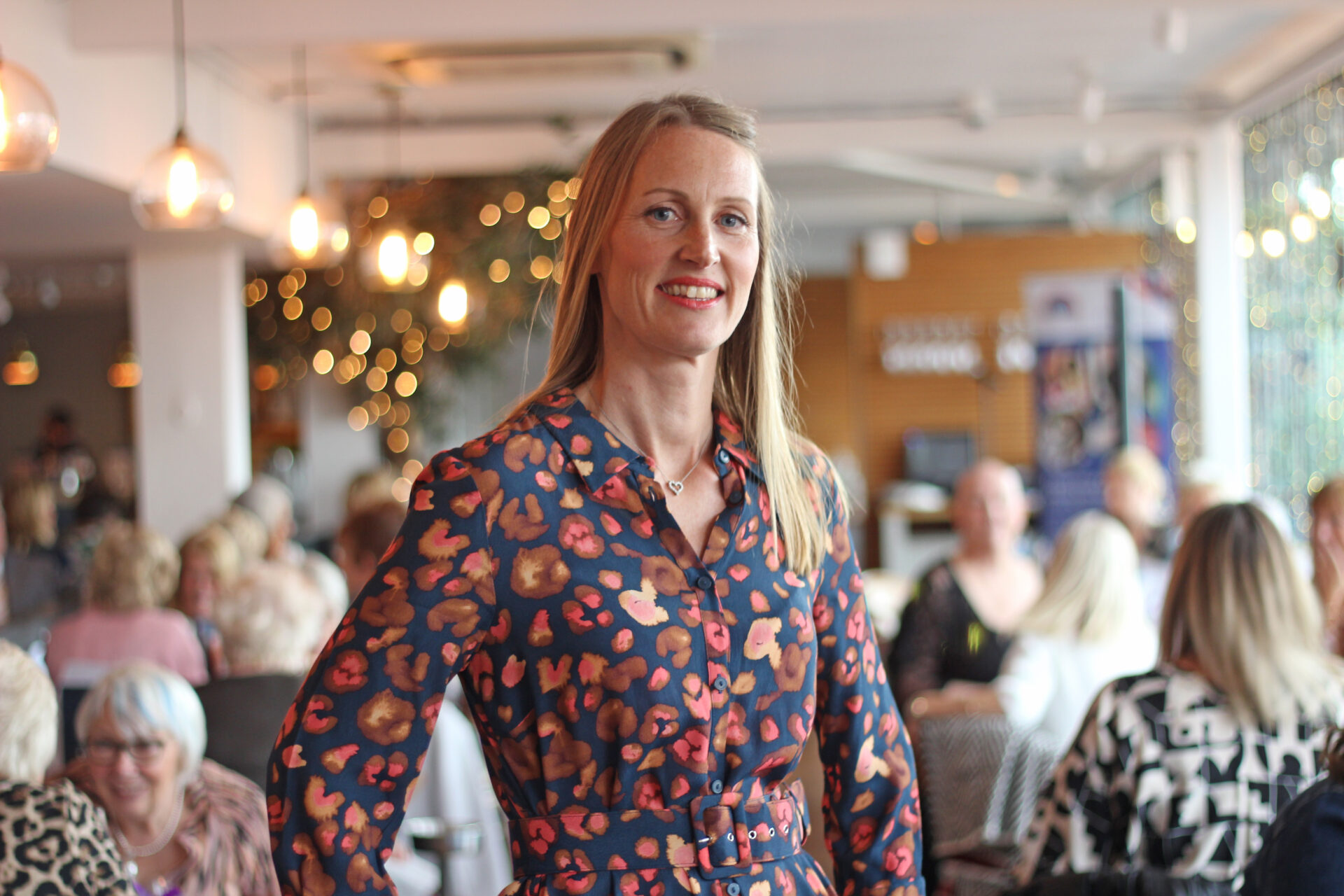 Woman wearing a multi-coloured dress stood in a restaurant