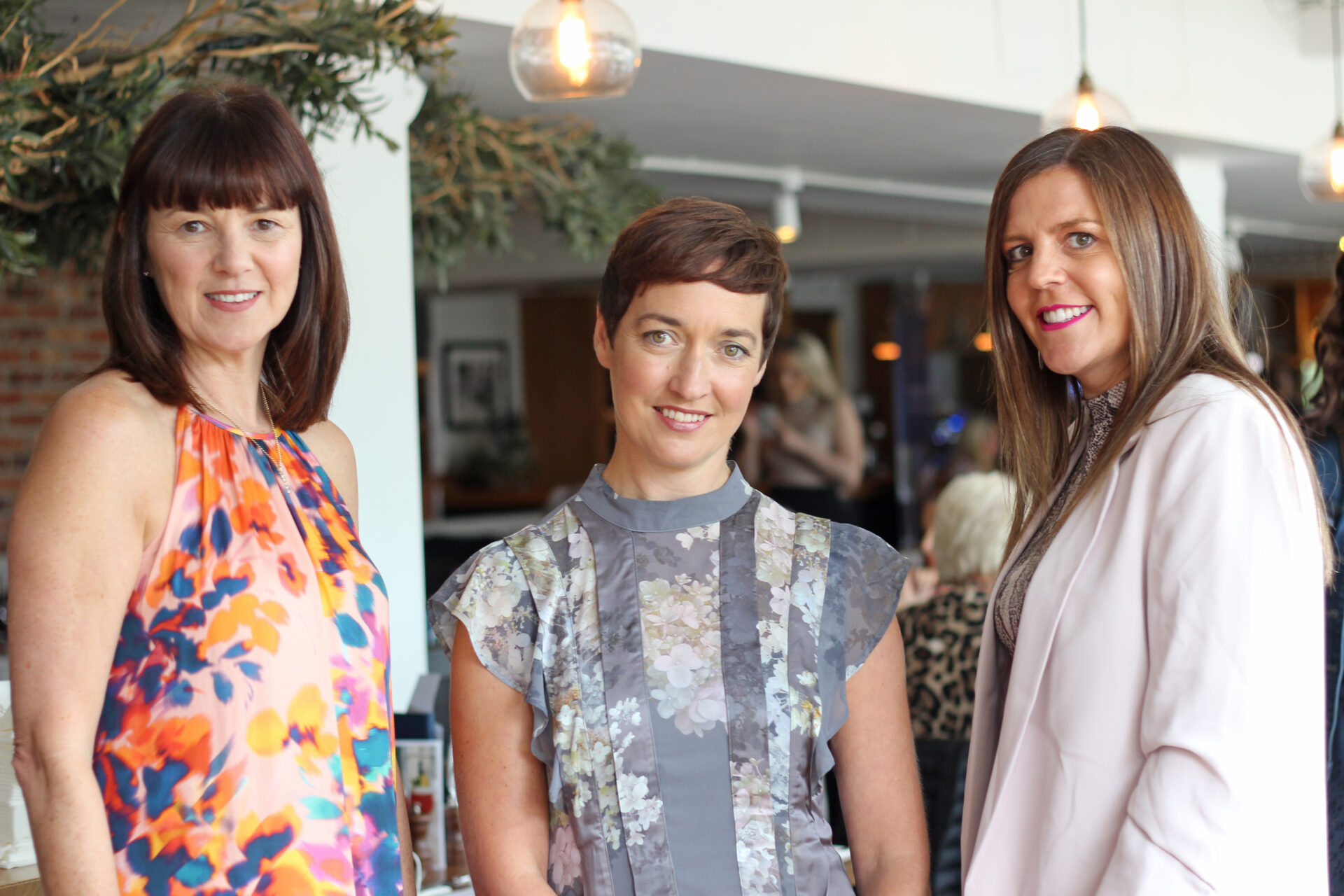 Three women stood in a restaurant