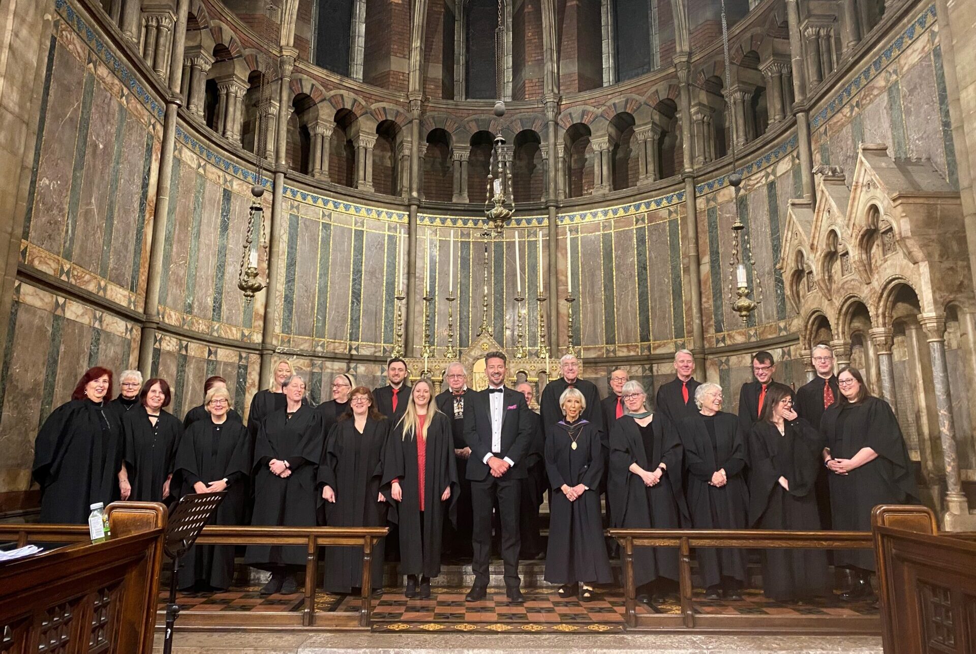 A choir stood in front of an altar in a church.