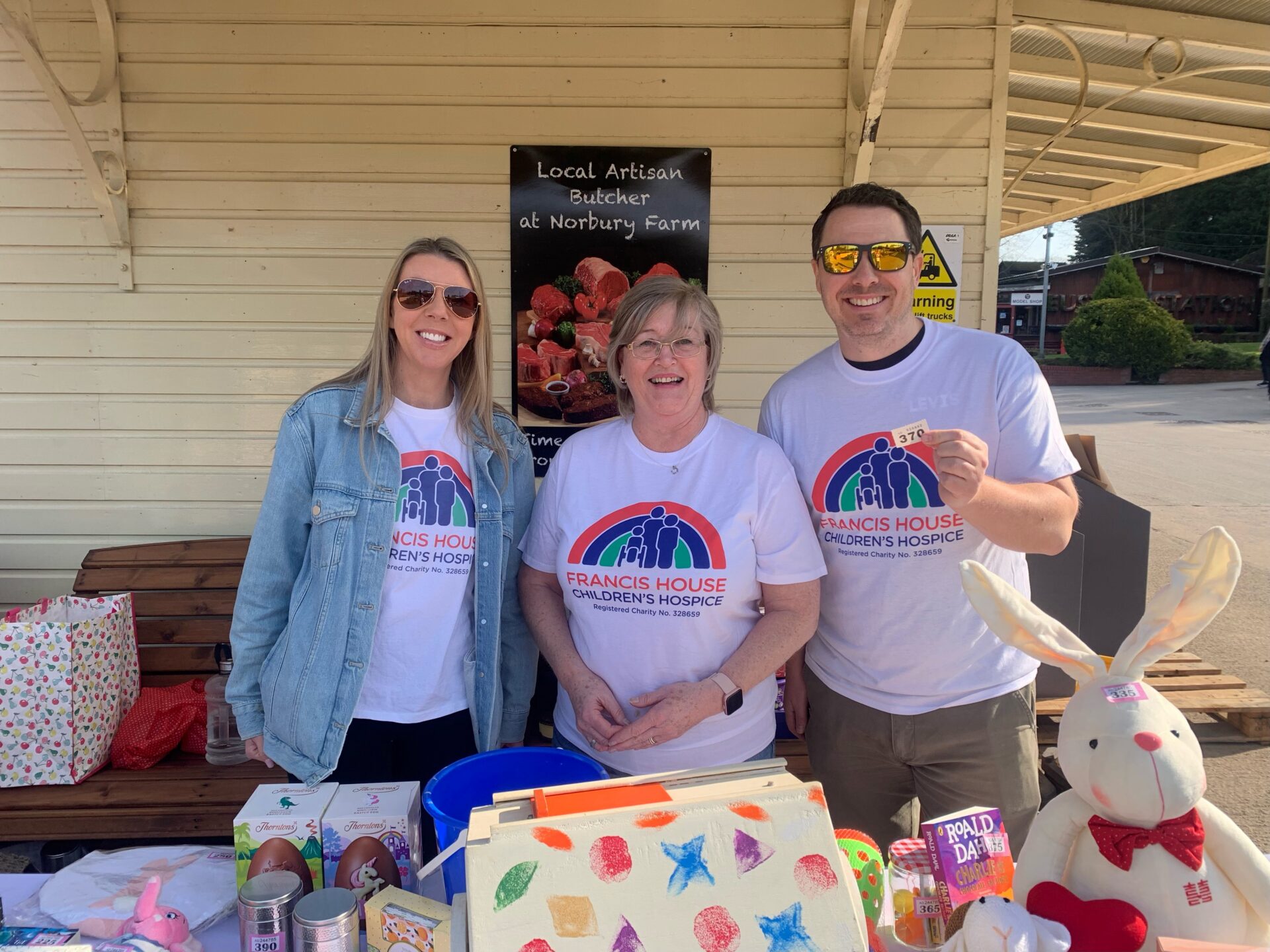 Three women volunteers at a charity tombola stall