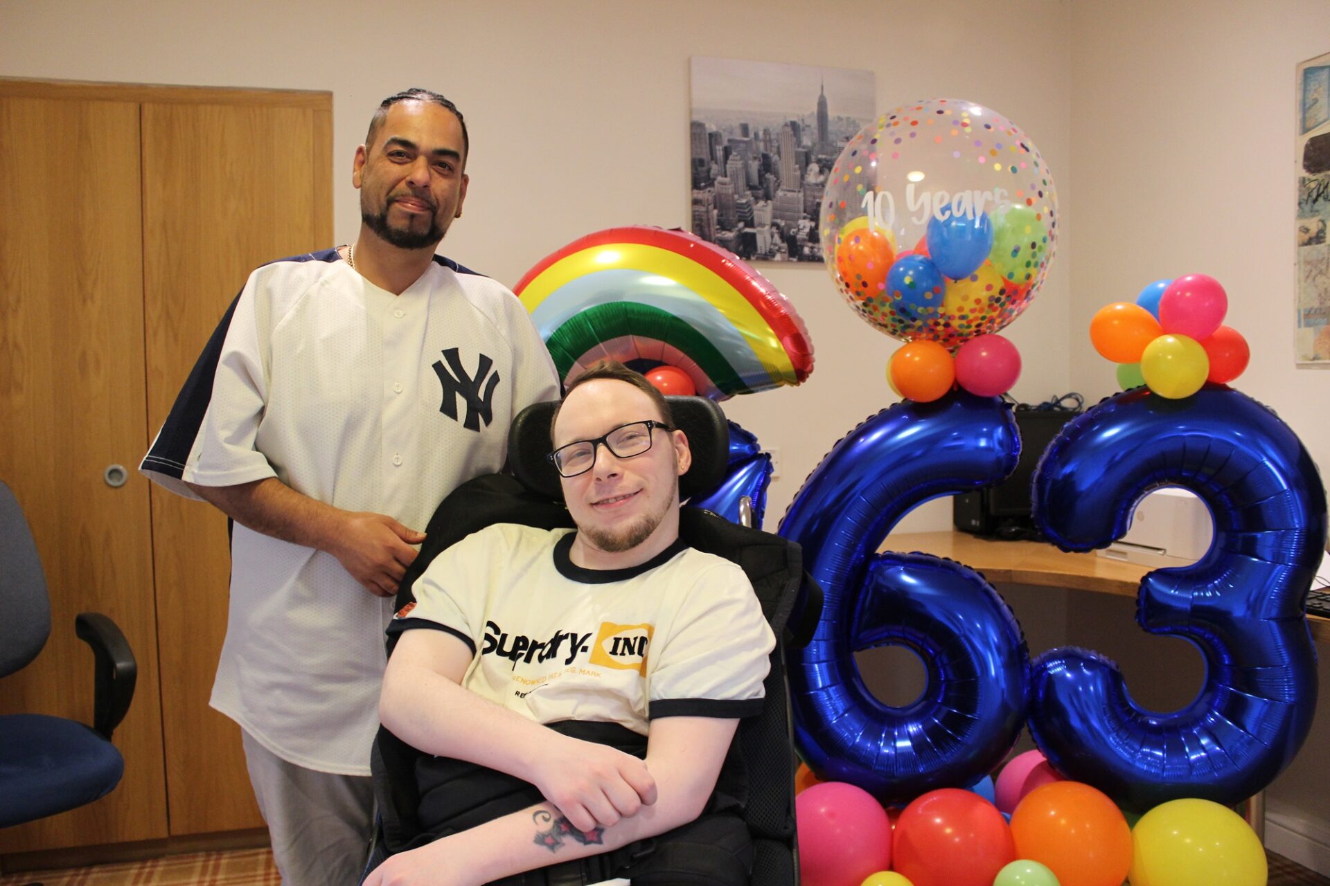 Winston Beharrie (staff member) and Christopher infront of balloons