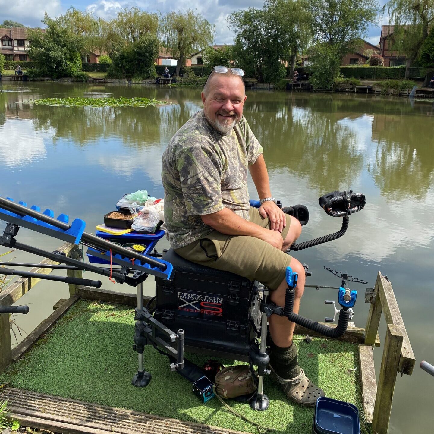Chairman of Reddish Angling Club, Danek Imiolek, sits at Jackson's Pond amidst all his fishing equipment