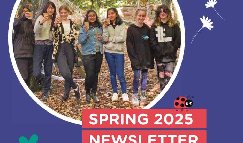 Cover of a newsletter featuring a photo of young people in a wooded area smiling at the camera