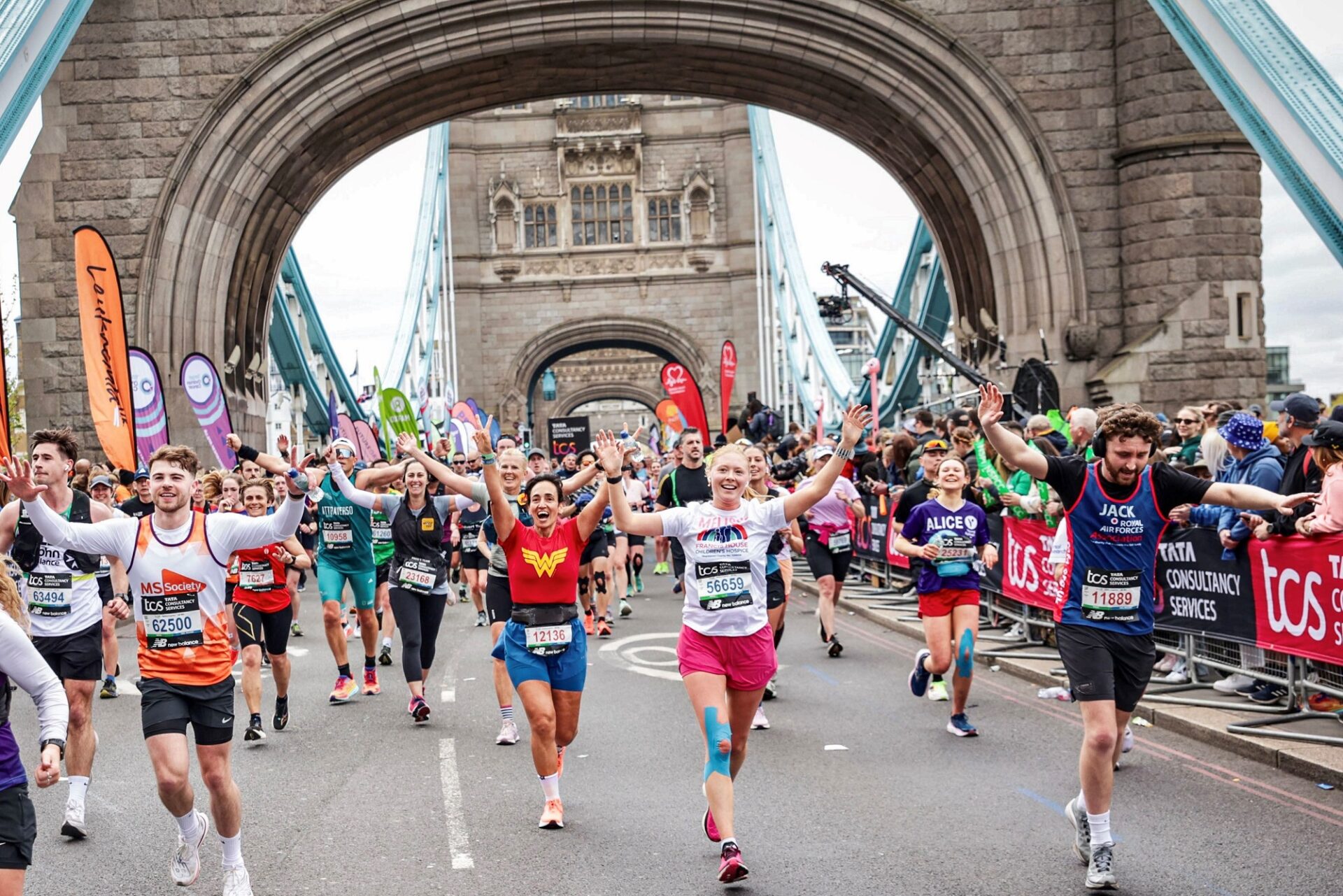 Large group of runners crossing London Bridge taking part in the London Marathon