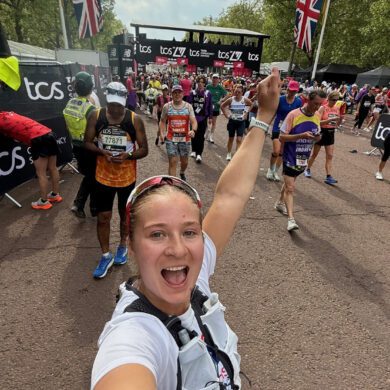 Woman taking a selfie with the fist in the air after running through the finish line at the London Marathon