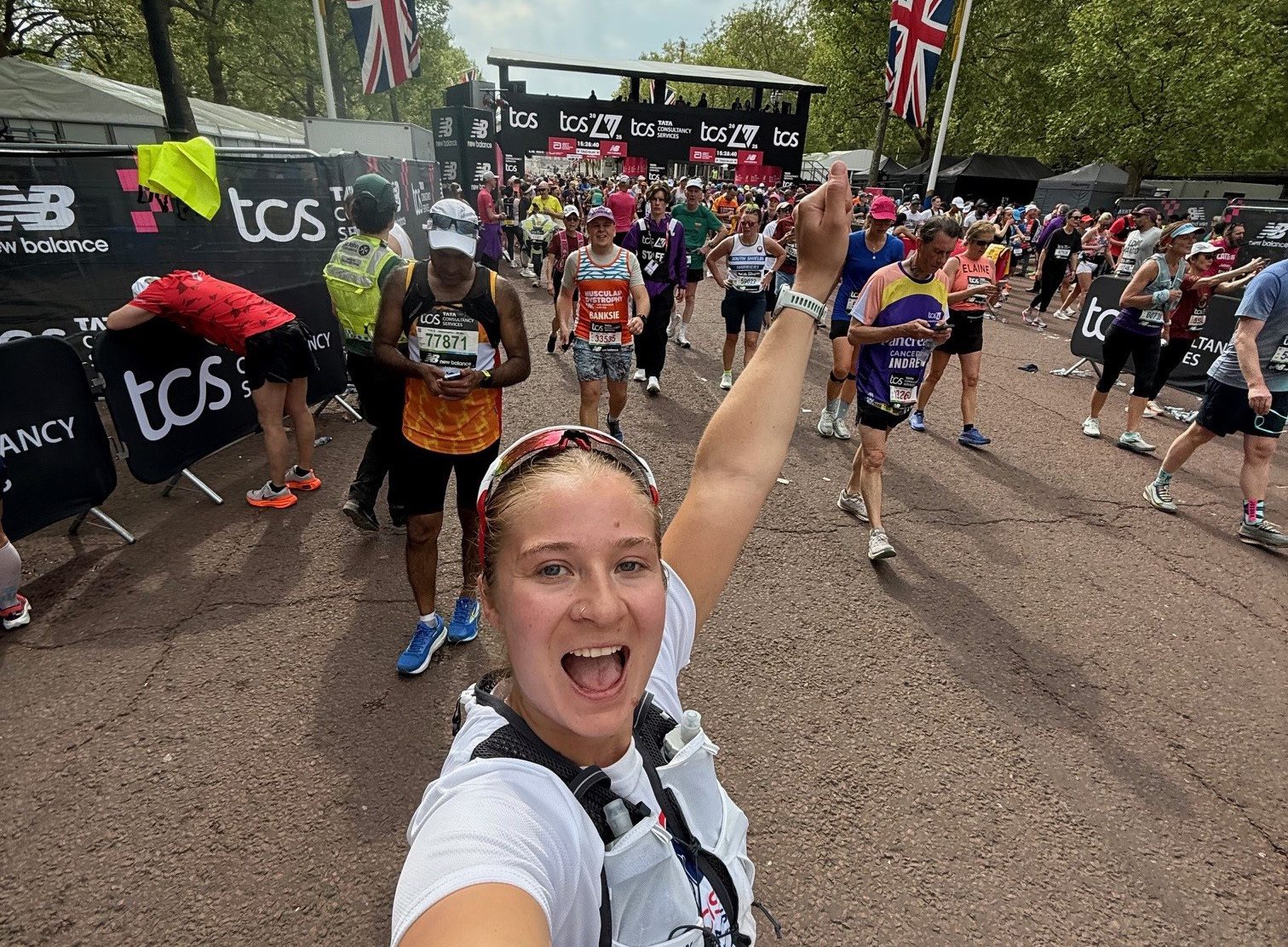 Woman taking a selfie with the fist in the air after running through the finish line at the London Marathon