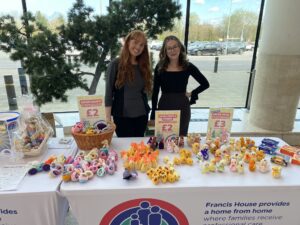 Two women stand behind a stall selling chicks in a shopping centre