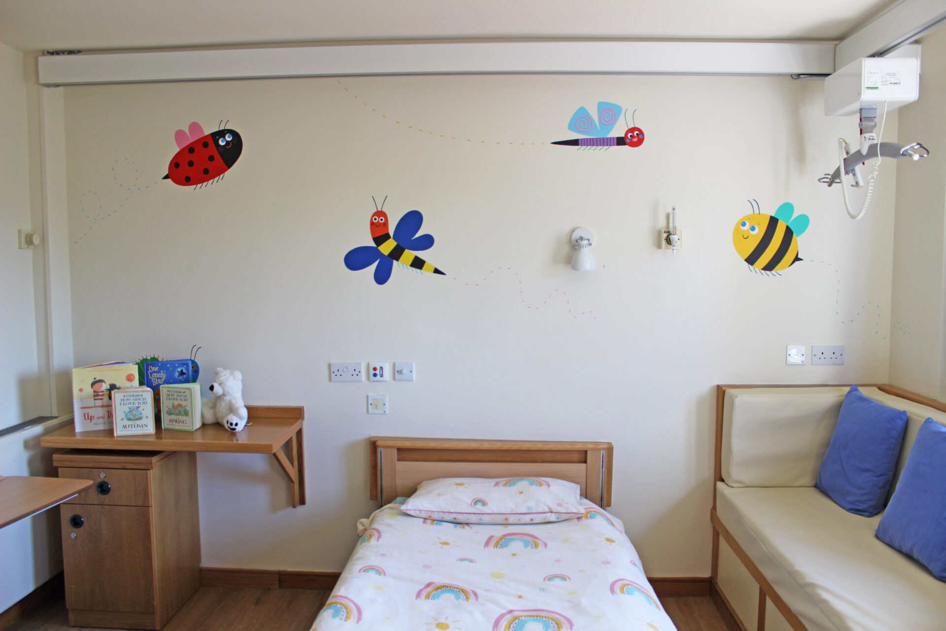 Child's bedroom with colourful painted bug characters on the walls