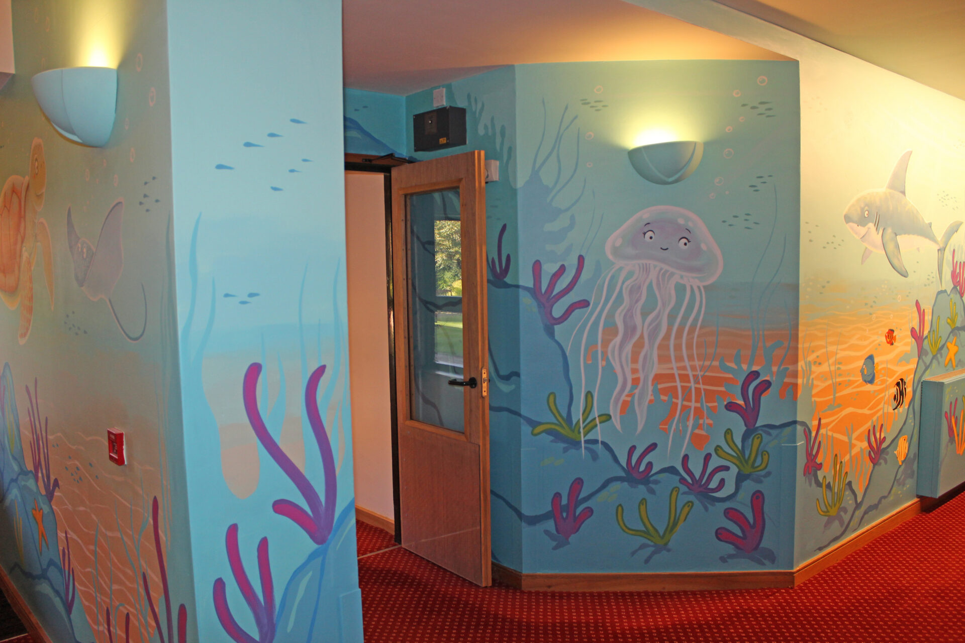 Painted undersea mural of cartoon creatures on a wall