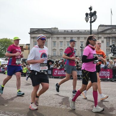 Group of runners in the London Marathon running past Buckingham palace