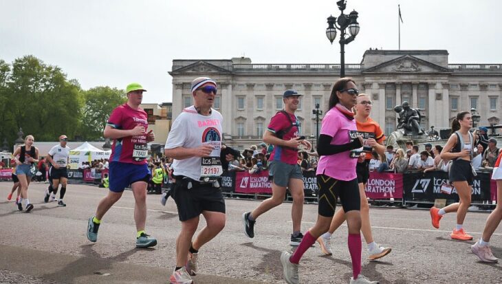Group of runners in the London Marathon running past Buckingham palace