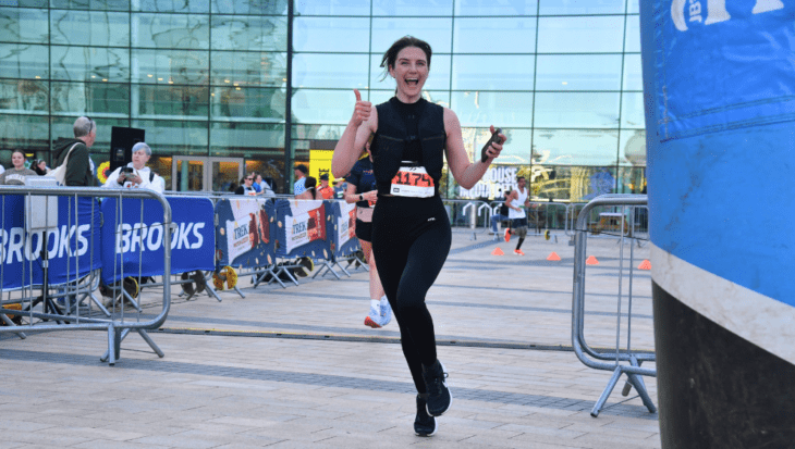 Girl crossing the finish line with thumbs up